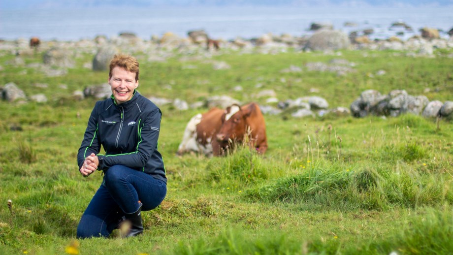 Bilde av Kristin Malonæs på beite med en ku i bakgrunnen.