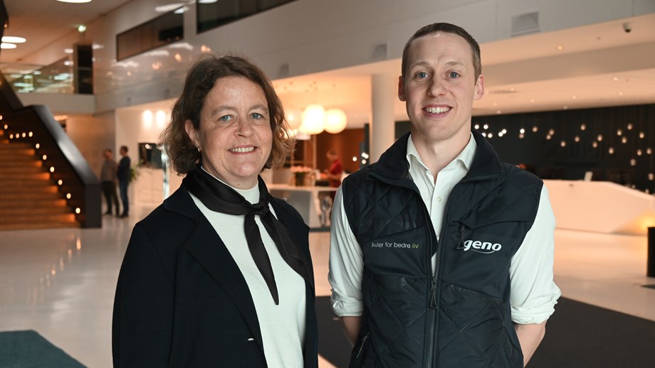 Nestleder og styreleder står oppstilt i hotellets vestibyle. De har begge på seg profilklær fra Geno.