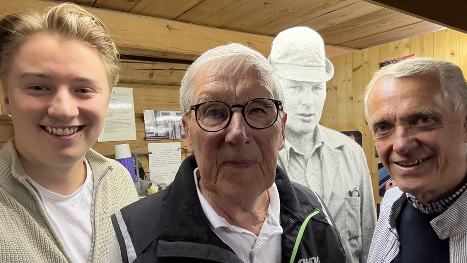 Programlederne og Odd Rise som er fotografert tett på med selfie. De står inne i seminmuseet med en pappfigur av en mann med hatt i bakgrunnen.